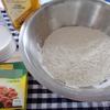 Chuẩn bị nguyên liệu. Bột mì cho vào tô cùng với muối, men nở trộn đều. Sau đó cho sữa hâm ấm từ từ vào nhồi đều khoảng 15 phút cho bột mịn dẻo không dính tay. Lấy màng thực phẩm bọc tô bột lại để bột nghỉ 20 phút.
