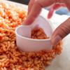 Tiếp theo, cho bỏng gạo vào hỗn hợp tan chảy, trộn đến khi bỏng gạo ngấm đều hỗn hợp nước. Trải lớp bỏng gạo lên trên khay nướng, để nguội. Sau đó, dùng khuôn bánh cắt thành từng hình trái tim từ lớp bỏng gạo ra.