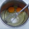 Cho trứng, dầu ăn, đường vào tô, dùng phới đánh tan. Rây bột phô mai, bột mì và bột nở vào tô.
