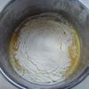 Cho trứng, dầu ăn, đường vào tô, dùng phới đánh tan. Rây bột phô mai, bột mì và bột nở vào tô.
