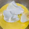 Cho 1/3 chỗ lòng trắng trứng vừa đánh vào thố lòng đỏ trứng, dùng spatula áp dụng kỹ thuật fold để khuấy hỗn hợp làm bánh bông lan quyện đều. Lặp lại tương tương cho 2 lần thêm lòng trắng tiếp theo. Cuối cùng thu được hỗn hợp làm bánh bông lan mịn màng.