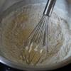 Cho phần 50gr bột mì vào hỗn hợp bơ, trứng, dùng phới lồng trộn đều. Lòng trắng, 70gr đường, 1/4 muỗng cà phê nước cốt chanh cho vào tô đánh bông trắng.