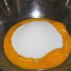 Đánh tan lòng đỏ trứng với 1 muỗng cà phê vani và 35g đường. Sau đó, trộn hỗn hợp lòng đỏ vào hỗn hợp bơ, sữa đang còn ấm, đánh đều để hỗn hợp hòa quyện.