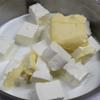 Đun cách thủy 60g bơ với 300g kem phô mai và 150ml sữa cho đến khi bơ tan ra, dùng muỗng khuấy đều cho đến khi kem phô mai hòa quyện vào hỗn hợp. Dùng rây lọc qua để hỗn hợp thêm mịn mượt.