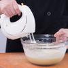 Trong một âu trộn lớn, cho kem phô mai, đường cát, nước cốt chanh và trứng gà vào đánh bông bằng máy đánh trứng.