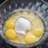 Tách lòng đỏ trứng và lòng trắng trứng để riêng. Cho bột mì, bột bắp, dầu ăn, sữa tươi vào tô lòng đỏ trứng gà, trộn đều.