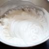 Dùng máy đánh trứng đánh lòng trắng từ số thấp đến số cao. Cho đường trắng vào từ từ đến khi lòng trắng bông xốp (úp ngược tô lòng trắng vẫn giữ nguyên).