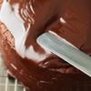 Phủ xốt chocolate bạn có được ở bước 3 lên trên, dàn đều. Rải hạt dẻ cười giã dập đều lên mặt bánh.