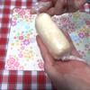 Cách làm bánh chuối cuộn Nhật Bản: Trải màng bọc thực phẩm ra , cho bánh có mặt trắng xuống dưới rồi thêm nhân lên mặt bánh trên. Nhẹ nhàng cuộn lại, xoắn thật chặt màng bọc để định hình bánh.