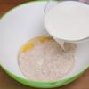 Đầu tiên, cho trứng gà, bột mì, 1/2 muỗng cà phê muối vào tô. Đổ từ từ 240ml sữa tươi vào, khuấy đều.
