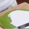 Trải từng miếng bánh crepe trà xanh ra mặt phẳng xếp chồng lên nhau, xen kẽ giữa các miếng bánh crepe là bánh cho kem sữa tươi, tráng đều.