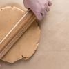 Loại bỏ lớp túi nilon rồi đặt khối bột lên trên giấy nến, cán mỏng miếng bột (để bột dày khoảng 0,6mm) thành một hình chữ nhật lớn. Phủ một lớp nhân lên trên miếng bột vừa cán mỏng. Cẩn thận cuộn miếng bánh lại, nên cuộn chặt tay giống như khi bạn làm cơm cuộn (kimbap). Dùng chỉ để xắt bánh ra thành từng khoanh. Không nên cắt khoanh mỏng quá, nên để khoanh dày từ 2 - 2,5 đốt tay.