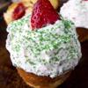 Phần kem tươi đánh bông cứng, dùng túi bắt kem lên phía trên bánh. Rắc đường màu và trang trí dâu tây lên mặt bánh. Vậy là bánh cupcake cây thông đã hoàn thành.