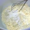 Trộn bột nở và muối nở với bột mì rồi rây bột vào hỗn hợp trên, thêm nho khô trộn đều.