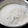 Cho 200gr sữa đặc vào chảo chống dính. Cho 150gr dừa nạo sấy vào chảo sữa.