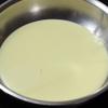 Cho 200gr sữa đặc vào chảo chống dính. Cho 150gr dừa nạo sấy vào chảo sữa.