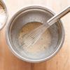 Tách lấy lòng trắng 4 quả trứng cho vào bát hoặc tô cùng với 125g đường, 2g muối và 1/4 muỗng cà phê vani. Trộn đều hỗn hợp cho đến khi đường tan và hỗn hợp nổi bọt.