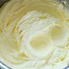 Bơ để mềm ở nhiệt độ phòng, cho bơ vào thố rồi thêm đường bột vào đánh cho quyện đến khi bơ nhạt màu (Chú ý cho từng ít một đường vào để hỗn hợp quyện nhanh hơn). Sau đó thêm từng lòng đỏ trứng vào đánh cho trứng quyện với bơ là được.