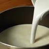 Cho 250ml nước cốt dừa và 450ml sữa tươi không đường vào nồi nhỏ. Khuấy đều hỗn hợp và nấu đến khi có hơi khói bốc nhẹ, thử tay vào sữa dừa hơi nóng ấm thì tắt bếp.