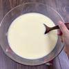 Đổ từ từ sữa dừa vào âu trứng đường. Vừa đổ vừa khuấy đều để các nguyên liệu hoà quyện với nhau.