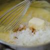 Khi hỗn hợp sệt lại thì bạn cho dừa, vani và bơ vào, trộn đều. Đổ hỗn hợp lên phần đế bánh đã được nướng và để nguội.