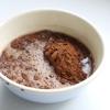 Làm nóng lò nướng ở nhiệt độ  350 độ F (180 độ C). Đổ 250ml nước sôi vào chén chứa bột cacao, khuấy đều. Thêm kem chua và tiếp tục khuấy đến khi các nguyên liệu hòa quyện.