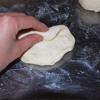 Lấy chút bột mì phủ lên bàn để cho bột không dính. Dùng tay dàn bột ra mỏng vừa, xếp lại tạo hình bánh mì.