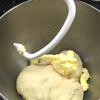 Cho phần bơ đã mềm vào, tiếp tục nhào để khối bột đồng nhất. Bọc khối bột lại đem ủ tiếp 50 phút sau khi bột nở gấp đôi, ấn ngón tay xuống khối bột không bị phồng lại là được.