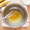 Cho 2 trứng gà vào tô, đánh cho đến khi hỗn hợp mượt. Thêm sữa tươi và tinh chất vani, đánh đều.
