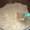 Cho 200g bột mì, 35g đường và 3g men nở vào thau, từ từ cho 100ml sữa tươi vào, trộn đều.