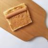Bánh mì sandwich bạn cắt bỏ phần rìa màu nâu bên ngoài bánh. Sau đó phết bơ đậu phộng lên trên bề mặt bánh mì cho đều. Xúc xích lấy ra, cắt đôi và để lên chiếc bánh mì đã được phết bơ.