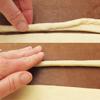 Tiếp theo, cuộn từng đoạn bột đã cắt thành sợi tròn như thế này nghen. Quấn từng dải bột quanh đui bóp kem để tạo hình giống củ cà rốt.