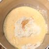 Cho 300g bột vào tô trộn, 5g men nở, trộn đều rồi thêm 50ml mật ong vào. Cho từ từ 200ml sữa và 1 quả trứng gà vào trộn đều, thêm 4g muối và nhồi cho đến khi hỗn hợp tạo thành khối thì cho bơ đã đun chảy vào nhồi.