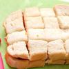 Đặt 1 lát bánh mì sandwich lên trên. Dùng dao cắt bánh mì sandwich đã kẹp thành những miếng nhỏ, hình vuông.
