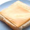 Cho 1 lát bánh mì sandwich ra đĩa, đặt phô mai lát lên trên. Cà chua rửa sạch, cắt khoanh tròn.