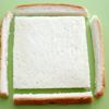 Cắt bỏ phần viền của bánh mì rồi cán nhẹ cho bánh mỏng ra.