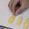 Chẻ đôi hạt đậu phộng rang, gắn lên mỗi đầu của bánh ngón tay, nên ấn nhẹ xuống cho đậu bám chặt. Làm lần lượt cho đến hết nguyên liệu.
