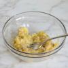 Nghiền nhuyễn 1 trái chuối trong tô lớn, cho sữa tươi, trứng gà, tinh chất vani vào trộn đều thành hỗn hợp đồng nhất. Trong một cái tô khác, trộn đều bột mì, đường, bột nở và muối lại với nhau