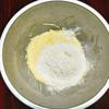 Rây bột mì vào tô bơ trứng, sau đó trộn đều nguyên liệu, hỗn hợp sẽ trở lên mịn mượt. Cuối cùng bạn múc ruột chanh leo cho vào, trộn đều là xong.