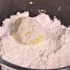Dùng môi múc hỗn hợp thả vào chén đường bột, lăn đều cho đường dính vào bột.