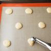 Dùng đồ múc kem, múc từng scoop bột ra, ấn dẹp, để lên khay nướng có lót sẵn giấy nến. Nên để bột xa nhau để bánh không bị dính vào với nhau.