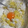 Đập 1 quả trứng gà ra chén, tách lấy lòng đỏ trứng, thêm bột mì, bột hạnh nhân, bột nở, 1/4 muỗng cà phê muối vào, trộn cùng hỗn hợp ở trên.