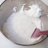 Đổ phần bột hạnh nhân vào chung với lòng trắng trứng, trộn đều, cho hỗn hợp vào túi bóp kem có gắn đui tròn.