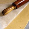 Đặt bột lên 1 tờ giấy nến, lấy 1 tờ giấy nến khác đặt lên trên khối bột, cán mỏng cho đến khi bột có độ dày khoảng 5mm.