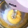 Dùng máy đánh trứng ở tốc độ nhanh để đánh bông trứng. Chia đường làm 3 phần bằng nhau và cho từ từ vào hỗn hợp trứng đánh. Đánh bông trứng đến khi tạo thành hỗn hợp trắng, bông mịn, đặc, cây đánh trứng tạo thành vết hình số 8 như hình là được.