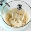 Cho phô mai, trứng, đường, vani và muối vào âu rồi dùng máy đánh trứng đánh đều sau đó thêm bột mì vào. Trộn cho đến khi hỗn hợp mịn mượt là được.