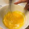 Trong lúc chờ bột, chúng ta sẽ làm nhân su kem. Tách lấy 2 lòng đỏ trứng gà. Tiếp theo là đánh tan lòng đỏ trứng với đường. Cần đánh cho đến khi trứng chuyển thành màu vàng nhạt là được.