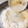 Trộn đều bột mì với muối rồi đổ men vào nhào thật kĩ. Khi bột đã được thành một khối mịn thì các cho bơ mềm vào nhào cùng đến khi bột không dính tay.