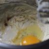 Đập trứng gà vào, thêm sữa chua, hỗn hợp bột mì, táo vào, trộn đều.