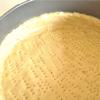 Dàn bột vào khuôn bánh và dùng nĩa xâm đều lên mặt bột. Lót một miếng giấy nến hoặc giấy bạc lên bột, đổ đầy đậu hoặc gạo để ngăn bánh bị phồng khi nướng.